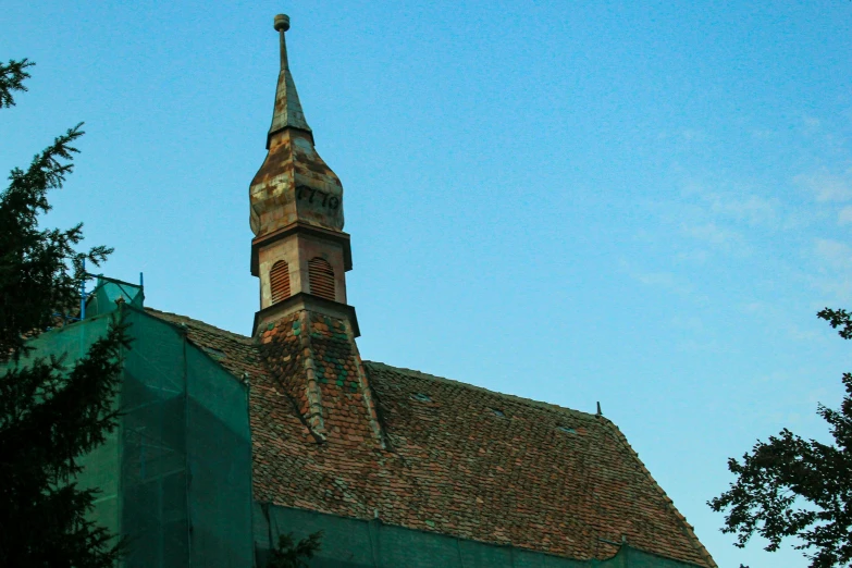 the building is green and there are a clock on the tower