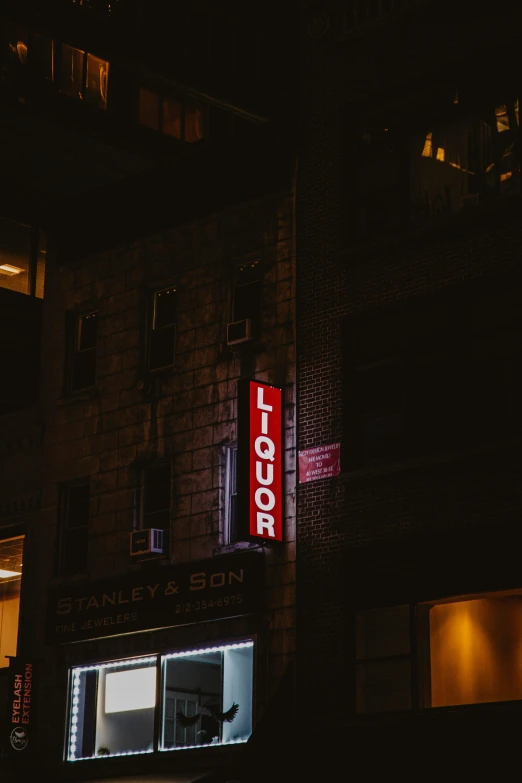 a tall building with a lit up red sign in the window