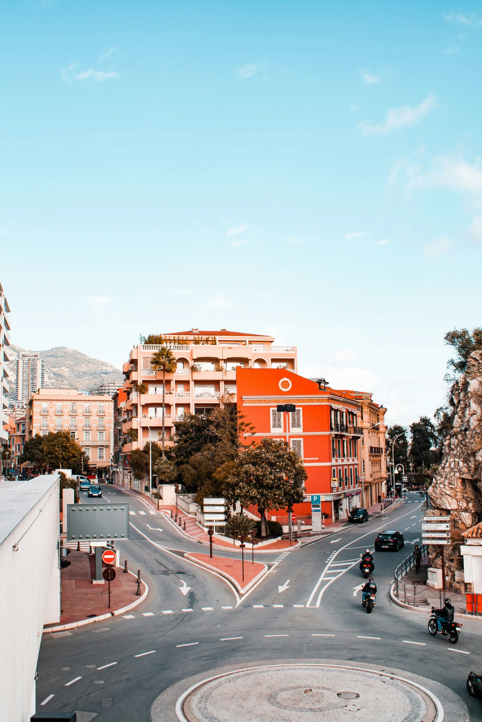 a city street with buildings and motorcycles driving down it