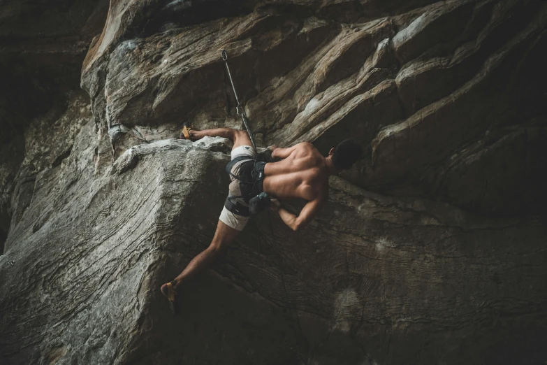 man climbing up a rocky cliff, with 