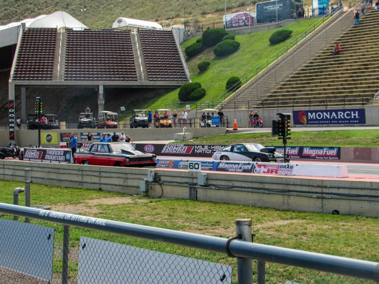 several race cars are driving on an empty track