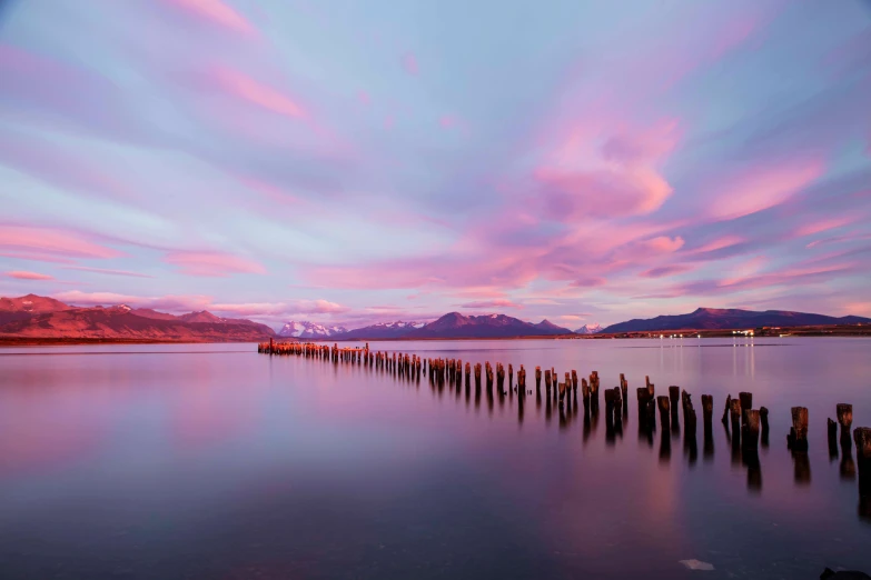 the sun is setting over water with multiple docks