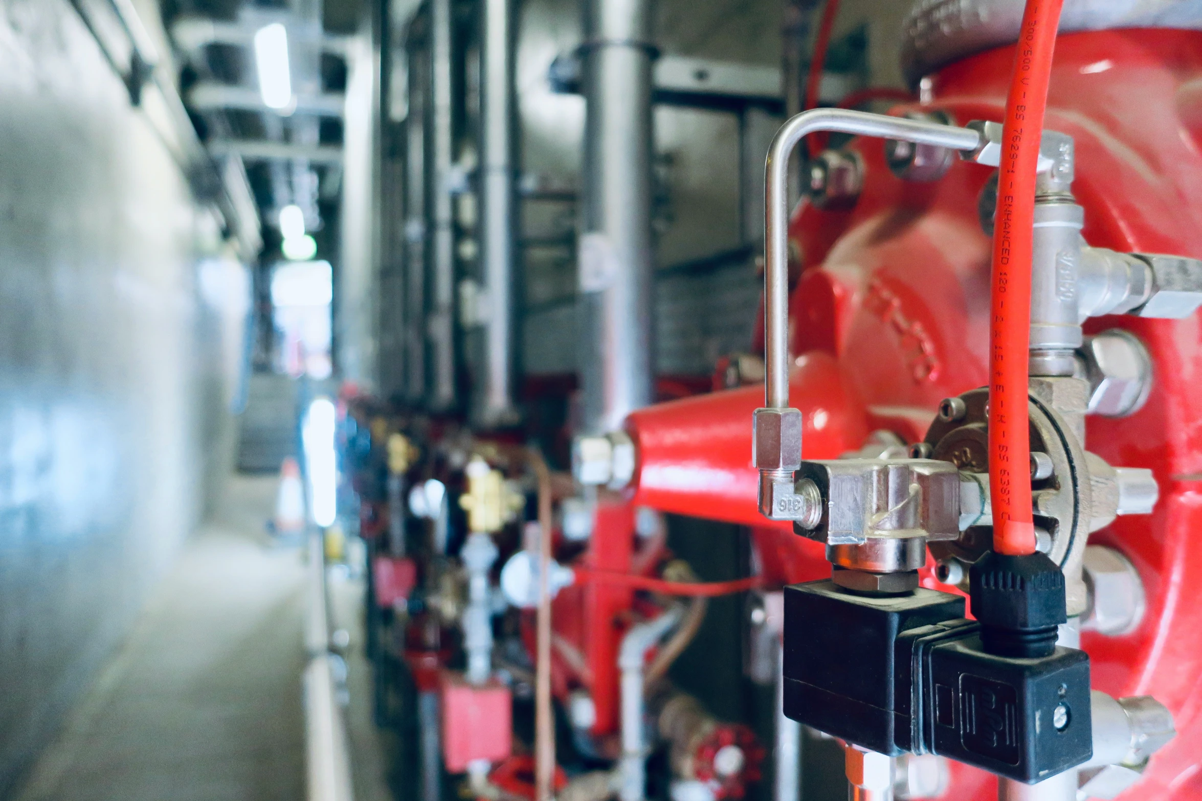 pipes in a building with red metal surfaces