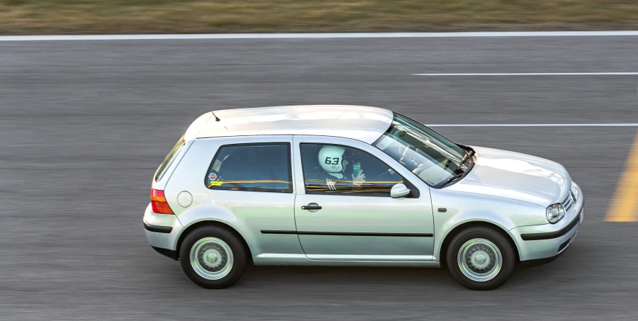 silver vw golf wagon driving on asphalt