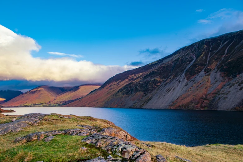 a body of water with many mountains behind it