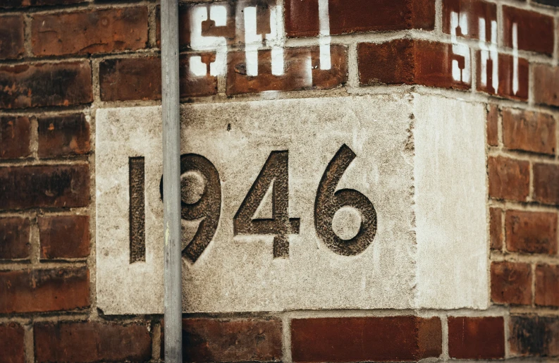 a number plaque attached to the side of a brick building