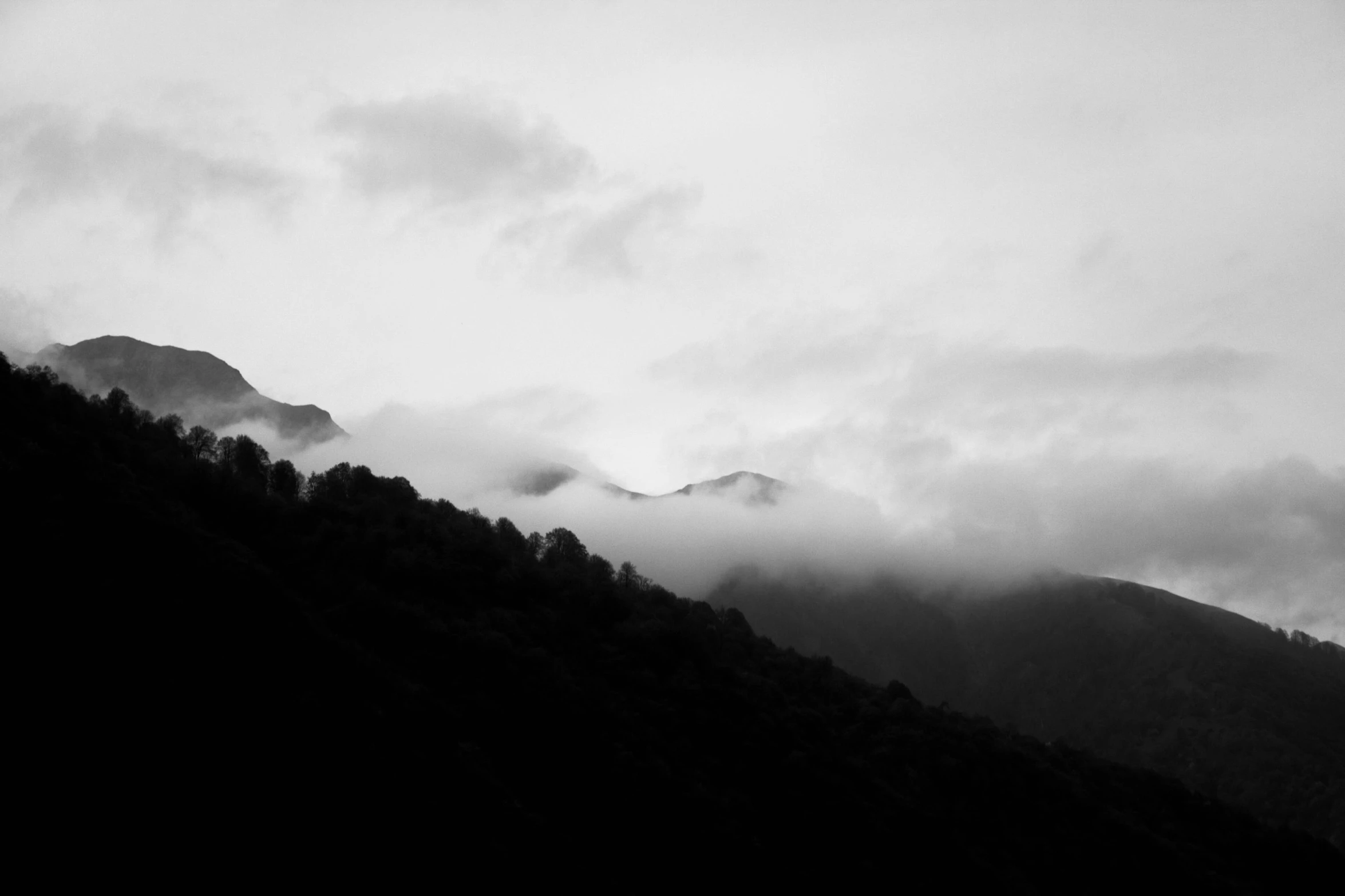 mountains rise up among a dark cloud and a mountain