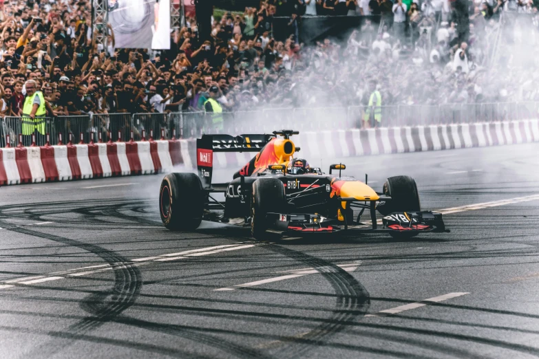 a race car races around a track in front of a crowd