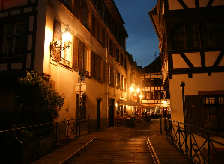 an alleyway with a small bridge in the middle between two building