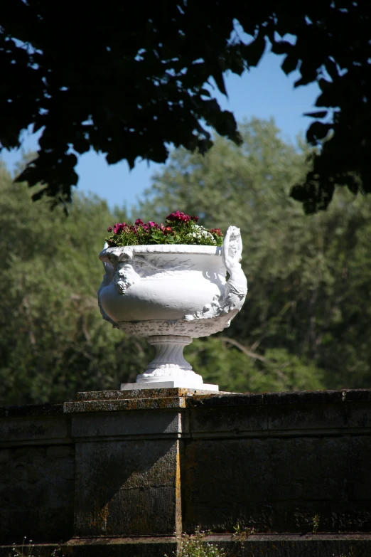 there is a white planter on top of a wall