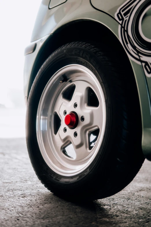 the tire of a small silver car on the road