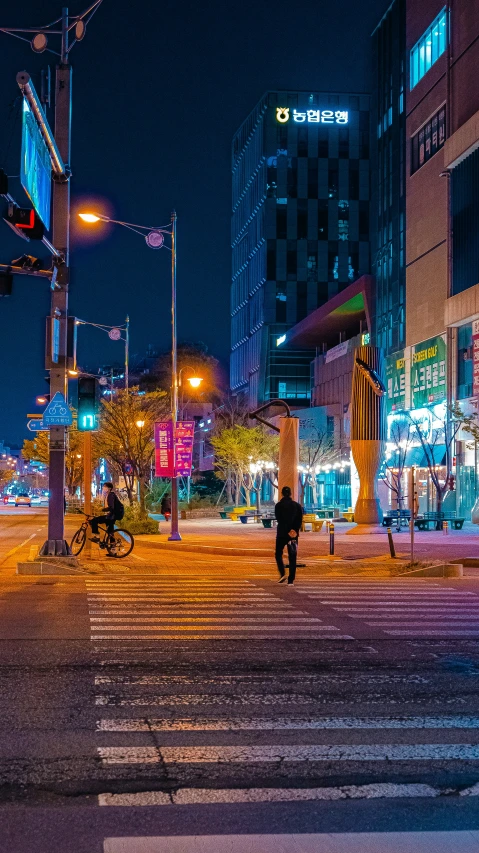 a city at night with tall buildings and street lamps