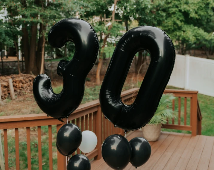 some black and white balloons are in the shape of letters