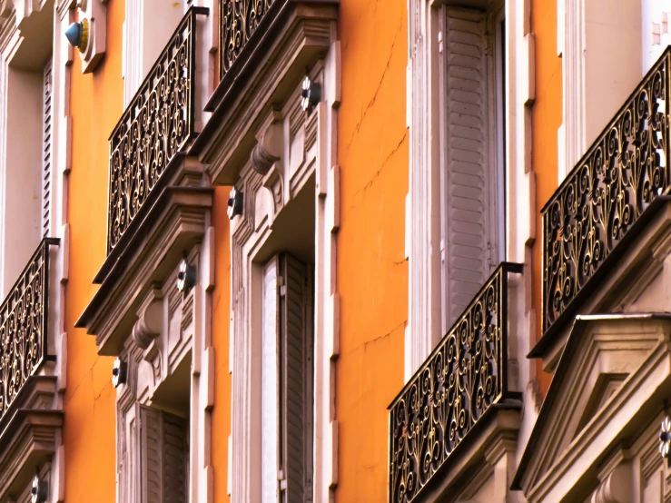 an orange building with white windows and balconies