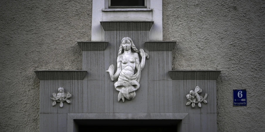 a large statue above a doorway to a very tall building