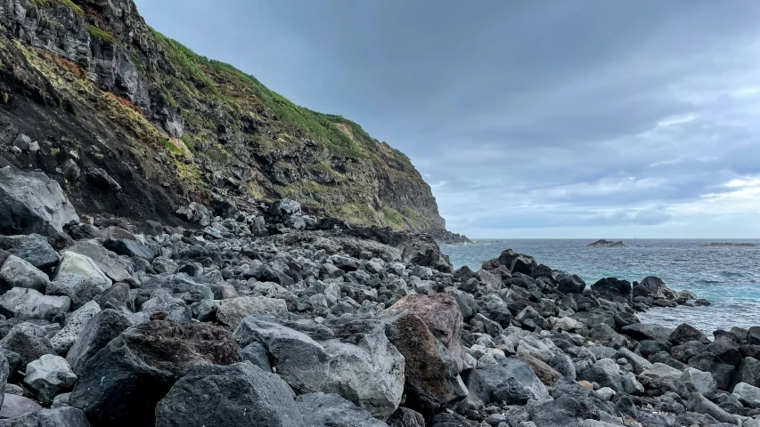 a cliff face is next to a large body of water