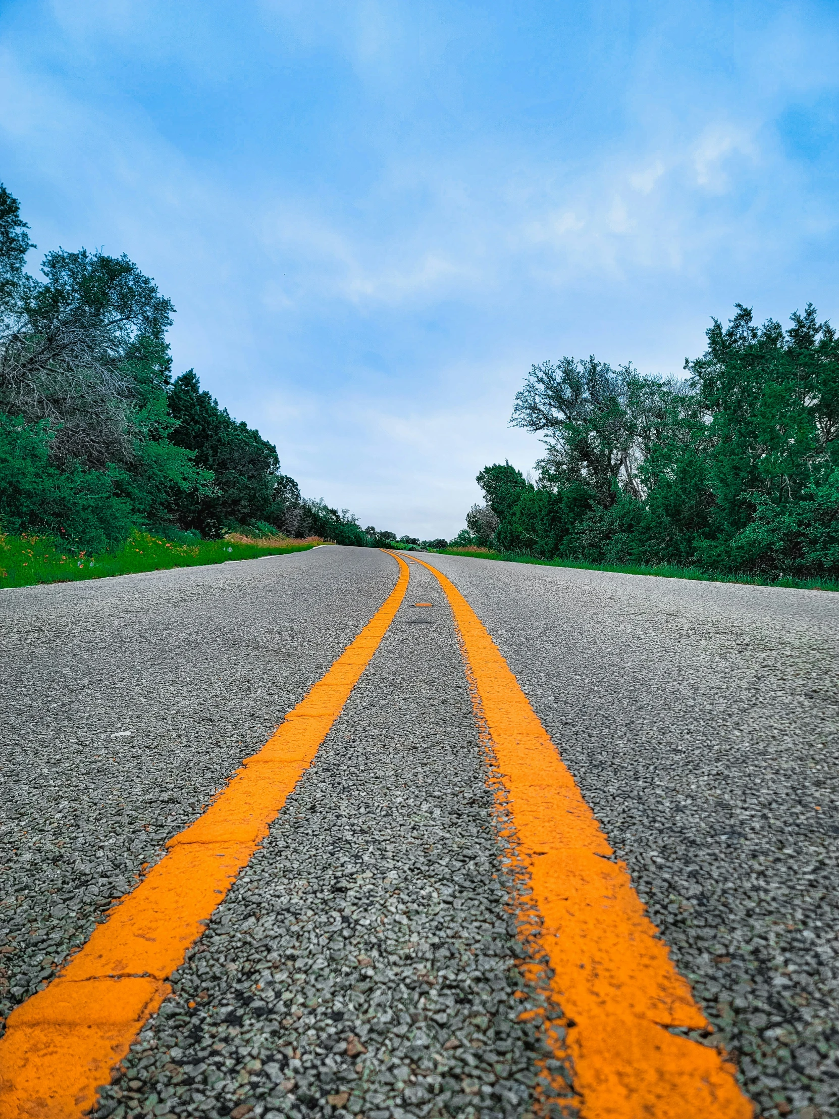 a long road with one yellow line painted on it