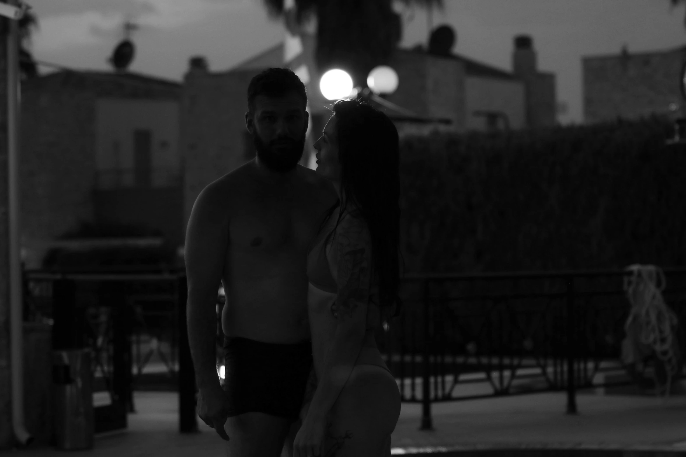 a man and woman are walking in their underwear at night