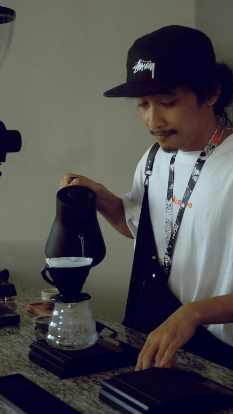 a man is using a grinder to make a coffee pot