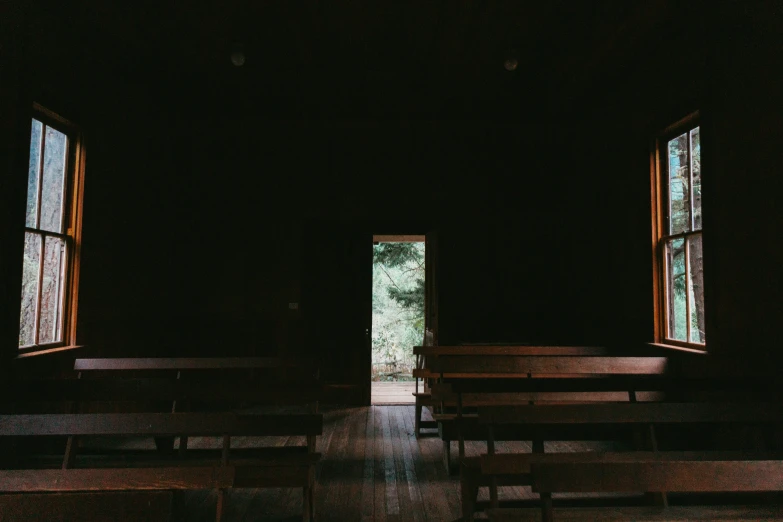 empty pews in an empty church with sunlight streaming through two windows