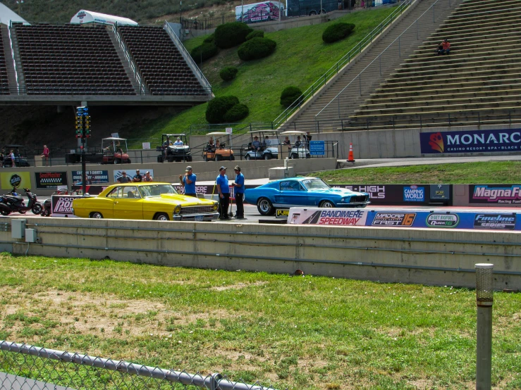 some old and new cars and people on a field