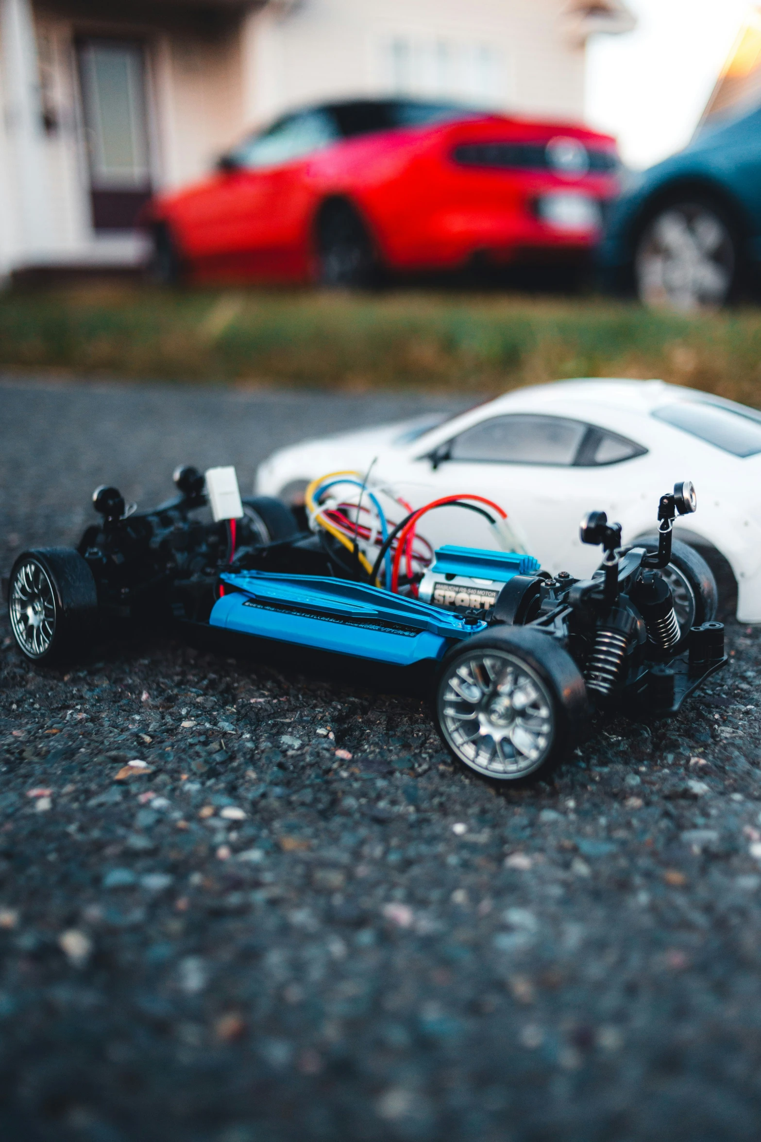toy cars sit on the ground beside their wheels