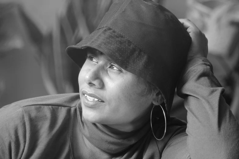 a black and white image of a woman wearing a hat