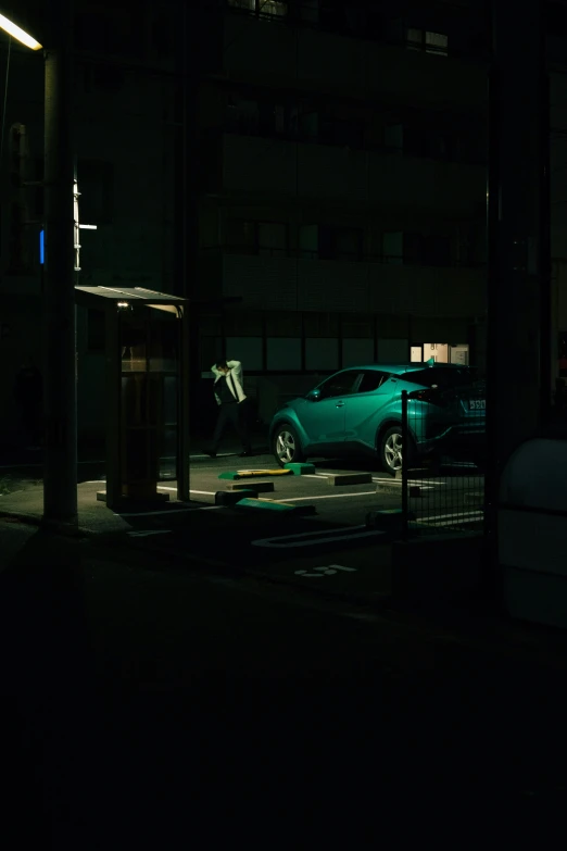 there is a green car that is in the dark
