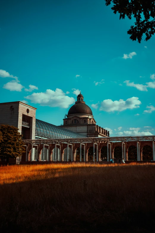 a building with an interesting roof on top sitting in a field