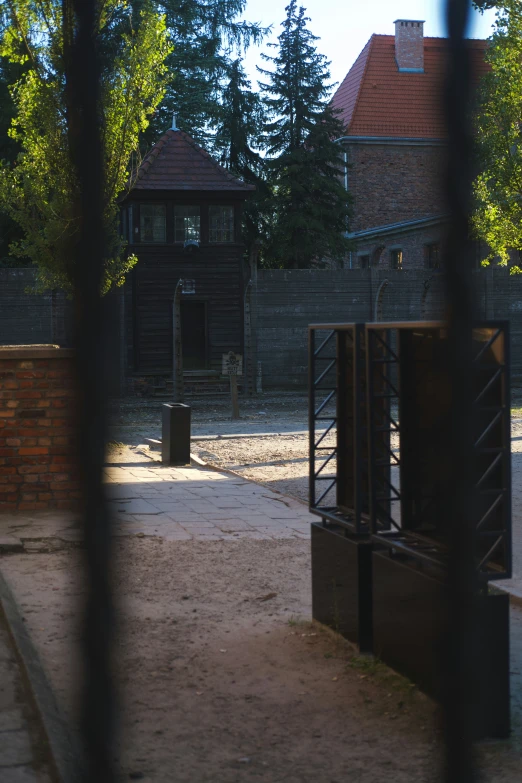 an empty gate near a red brick wall with a building behind it