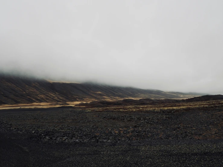 two people walk along a field towards a distant mountain