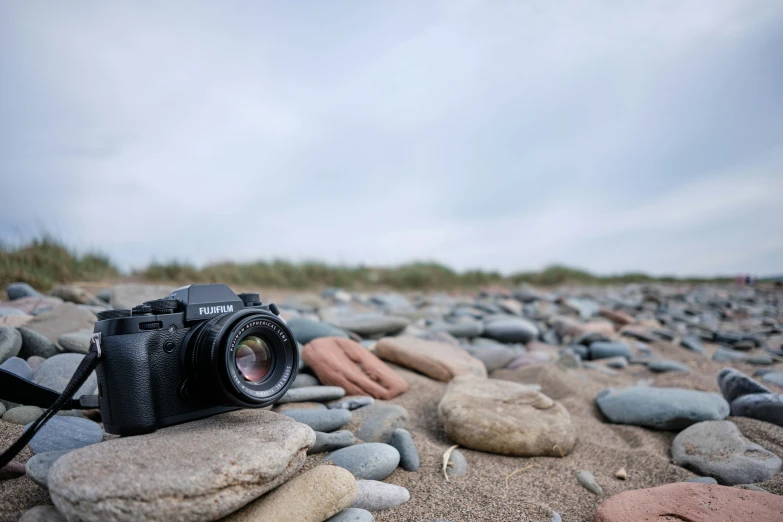 a digital camera resting on top of a bunch of rocks