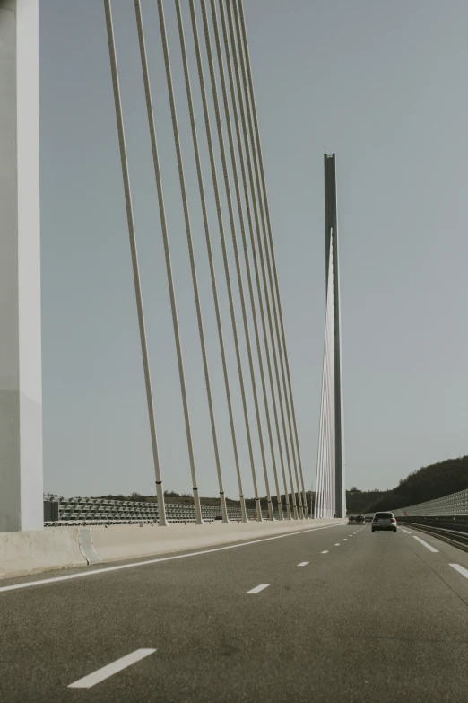 the car is riding over the bridge near other cars