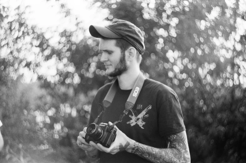 a man standing in a forest with a camera