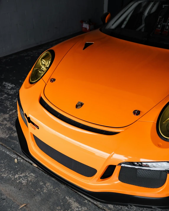 a close up of an orange sports car parked