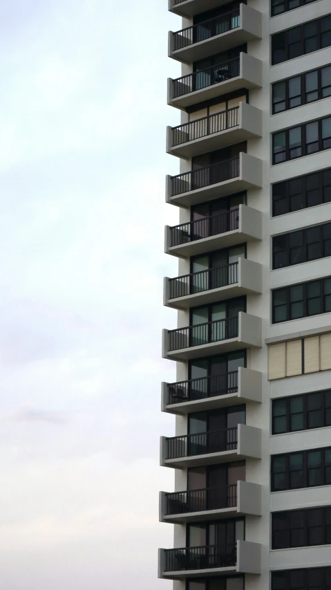 a tall white building next to the ocean