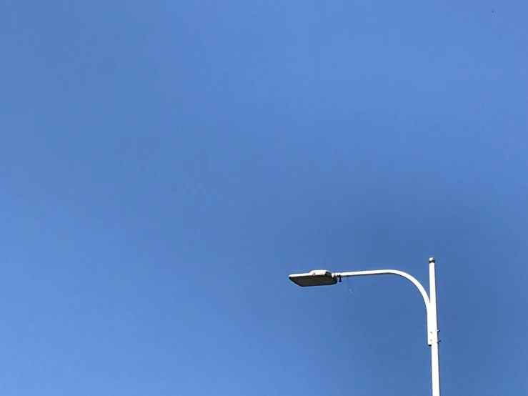 a street lamp and a sign against a blue sky