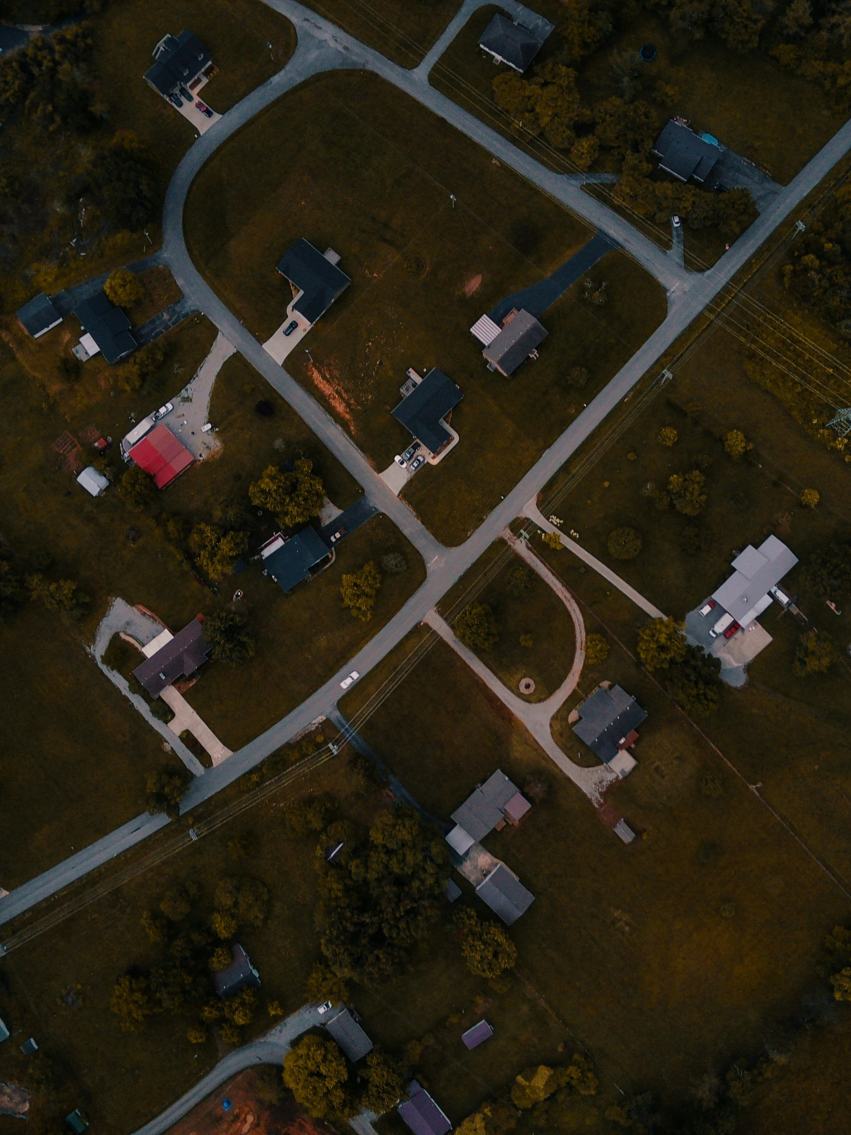 an aerial view of a street intersection with houses and trees