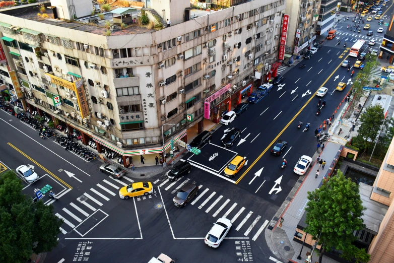 an aerial view of a street intersection with traffic and pedestrians