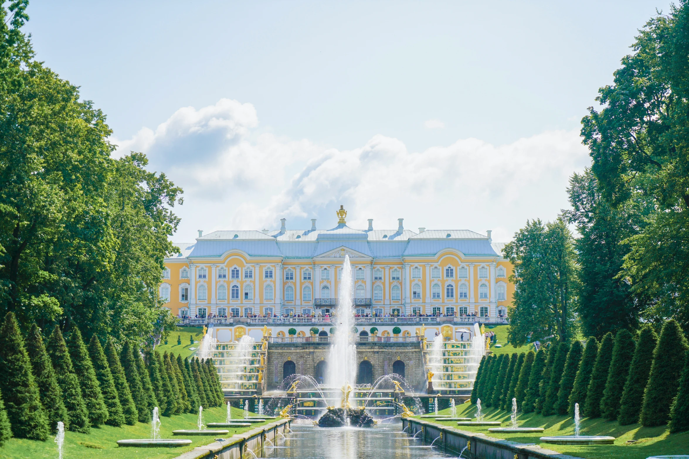 a building and fountain in a park surrounded by trees