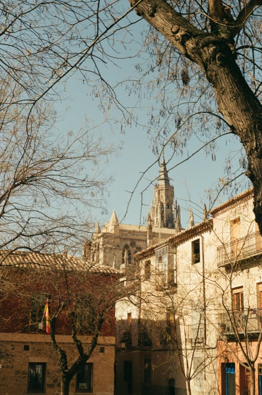 the view of an old church and buildings around it