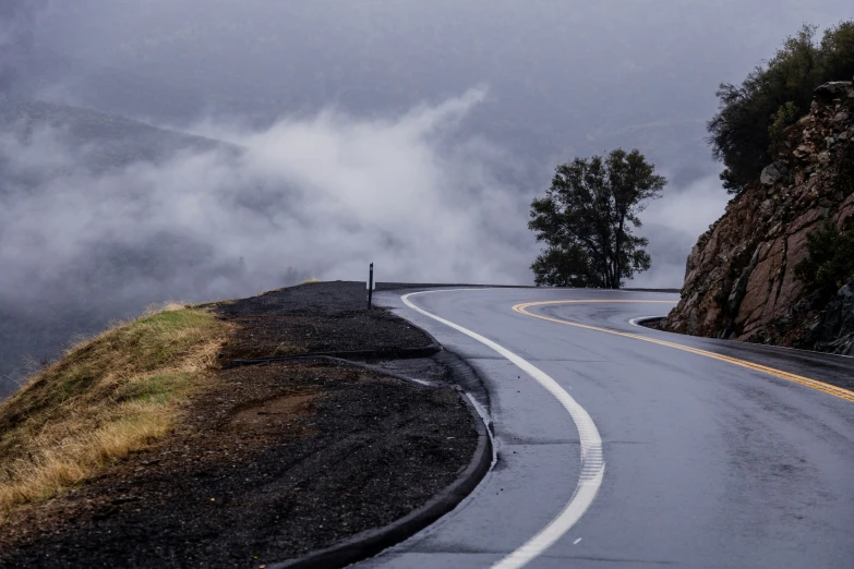 road curves in wet road with mountains in background