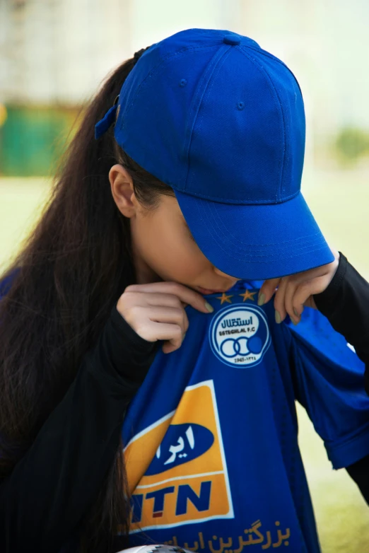 the young lady is trying to adjust her baseball uniform