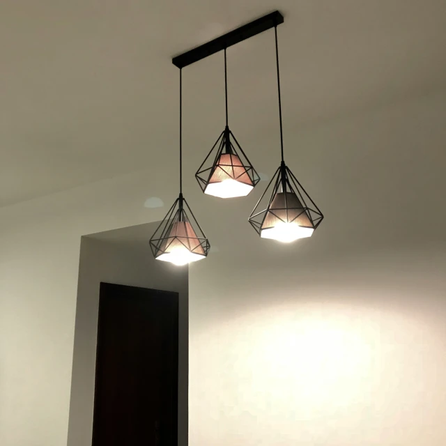 three glass lamps are suspended from a beam in the bathroom