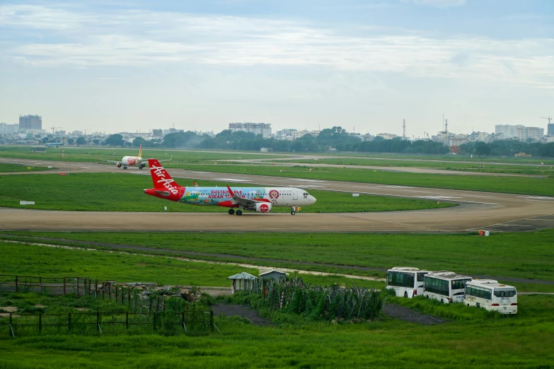 red and white airplane on runway with grassy area