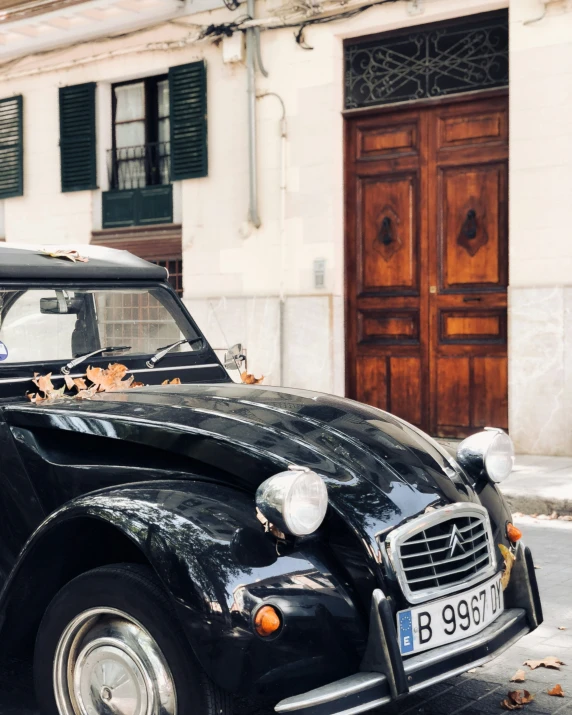 an antique classic black car is parked outside