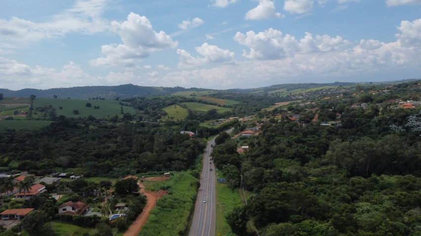 a wide view of trees, hills and a road on the other side