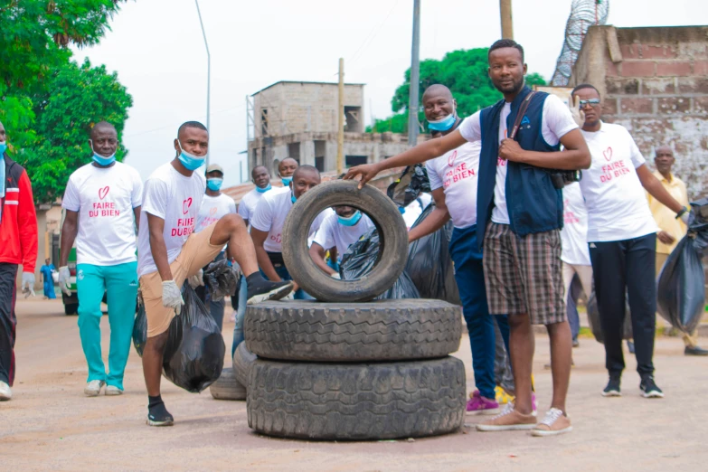 men with face masks hing up a tire