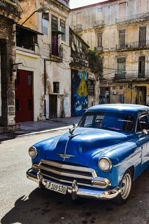 an old classic car is parked in the middle of a street