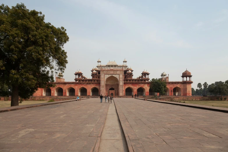 an ornate building stands near trees and a large road